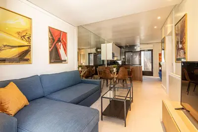 a living room with a blue couch and a dining room at BmyGuest - Vilamoura Golf Villa in Vilamoura