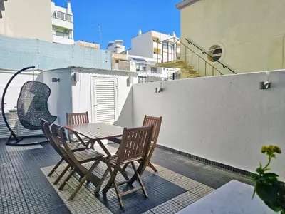 a patio with a table and chairs on a balcony at Blife Batalya private rooms in Faro