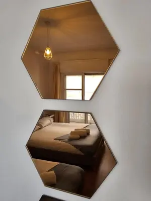 a mirror reflection of a bedroom with a bed at Blife Batalya private rooms in Faro