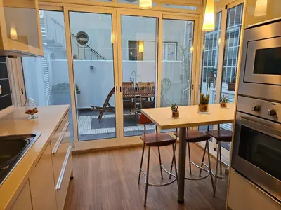 a kitchen with a table and chairs and a balcony at Blife Batalya private rooms in Faro