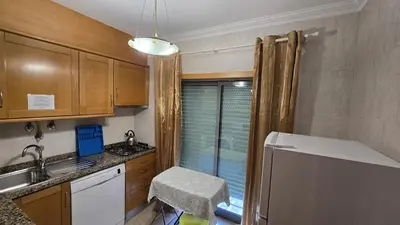 a kitchen with wooden cabinets and a chair in it at Beautiful Studio Letícia in Roja- Pé
