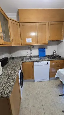 a kitchen with wooden cabinets and a sink and a dishwasher at Beautiful Studio Letícia in Roja- Pé
