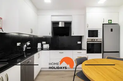 a kitchen with a table and a sign that says home holidays at #305 Albufeira Sea House by Home Holidays in Albufeira