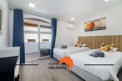 two beds in a room with a window and a room with two beds at #305 Albufeira Sea House by Home Holidays in Albufeira