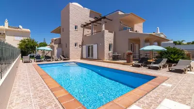 a villa with a swimming pool in front of a house at Villa Terramar - Golden & Salty in Guia