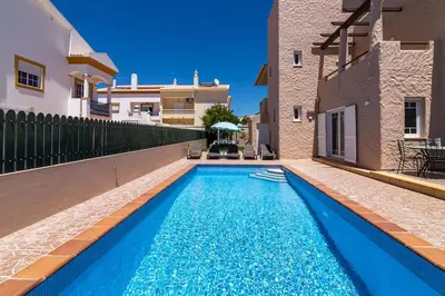 a swimming pool in the middle of a house at Villa Terramar - Golden & Salty in Guia