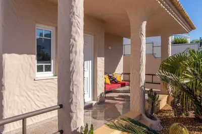 a porch of a house with a red couch on it at Villa Terramar - Golden & Salty in Guia