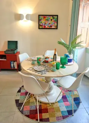 a dining room table with white chairs and a bottle of wine at Arty city house Casa Da Selva in Faro