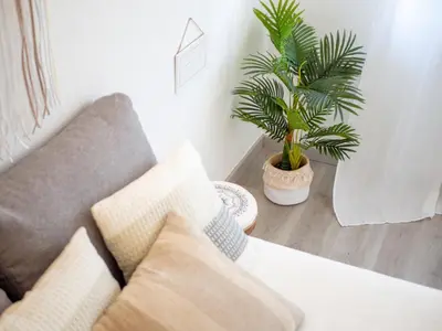a living room with a couch and a plant at Boho house, Albufeira in Albufeira