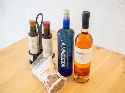 three bottles of wine sitting on a wooden table at Boho house, Albufeira in Albufeira