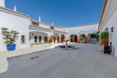 a courtyard of a white building with a fountain at Villa SOLAR DO MONTE 3 in Albufeira
