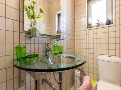 a bathroom with a glass sink and a toilet at NEW! Villa Balaia K-11 in Branqueira