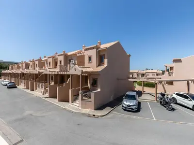 a row of buildings with cars parked in a parking lot at NEW! Villa Balaia K-11 in Branqueira