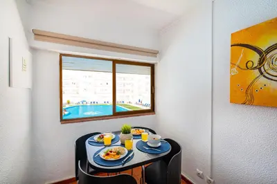 a table with plates of food on it with a window at Apartment Milos by Algarve Vacation in Albufeira