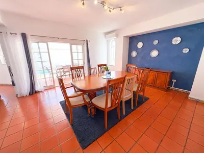 a dining room with a wooden table and chairs at Villa Mia - Peerless Bond in Albufeira