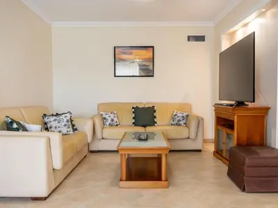 a living room with a couch and a tv at Oura Sunrise 3B Apartment by Stay ici Algarve Holiday Rental in Albufeira