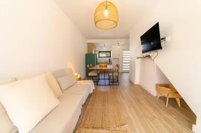 a living room with a white couch and a tv at Falésia Coast Villa by HelloVacations in Albufeira