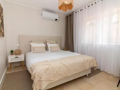 a bedroom with a large bed with white sheets and a window at Serenity 03 House by Stay ici Algarve Holiday Rental in Albufeira
