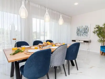 a dining room with a wooden table and blue chairs at Serenity 03 House by Stay ici Algarve Holiday Rental in Albufeira