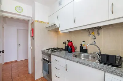 a kitchen with a sink and a stove top oven at T2 2 Linha Praia Vista Mar in Quarteira