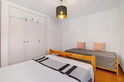 a bedroom with two beds and a closet at T2 2 Linha Praia Vista Mar in Quarteira