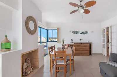 a living room with a table and a dining room at T2 2 Linha Praia Vista Mar in Quarteira