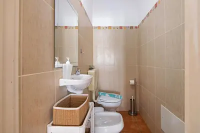 a bathroom with a toilet and a sink at T2 2 Linha Praia Vista Mar in Quarteira