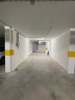 an empty parking garage with white walls and yellow stripes at Apartamento Noronki - Altos do Forte Novo in Quarteira