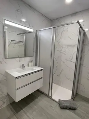 a bathroom with a white sink and a shower at Apartamento Noronki - Altos do Forte Novo in Quarteira