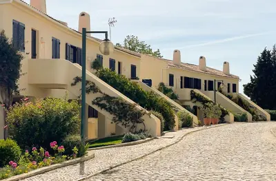 a bedroom with a large white bed and a patio at T2 Monte Sol HsRentals Vilamoura in Vilamoura
