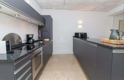 a kitchen with black cabinets and a counter top at Apartamento Mare Aveiros Beach in Albufeira