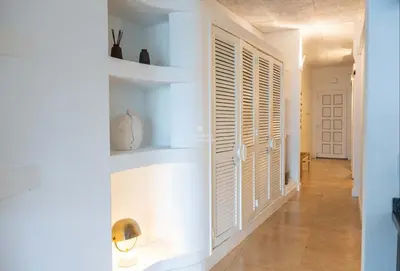 a hallway with white walls and white shutters at Apartamento Mare Aveiros Beach in Albufeira
