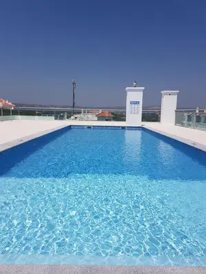 a large blue swimming pool on top of a building at Modern apartment on the beach of Falesia in Albufeira