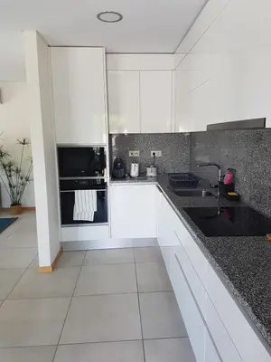 a white kitchen with white cabinets and a sink at Modern apartment on the beach of Falesia in Albufeira