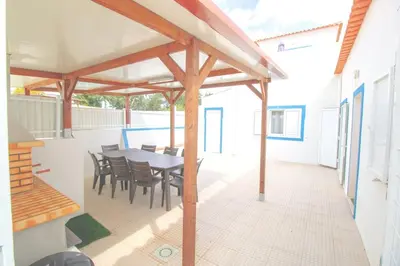 a patio with a table and chairs on a roof at Villa Azul in Boliqueime