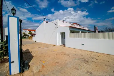 a white building with a blue pole in front of it at Villa Azul in Boliqueime