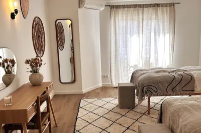 a bedroom with a bed and a desk and a mirror at Stunning beach apartment in Almancil