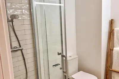 a bathroom with a toilet and a glass shower at Stunning beach apartment in Almancil