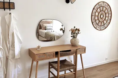 a mirror on a wall with a table and a bed at Stunning beach apartment in Almancil
