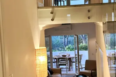 a living room with a table and chairs in a house at Stunning beach apartment in Almancil