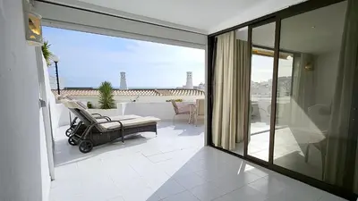 a room with a balcony with a chair and a view at Albufeira, Blue Wave Retreat 65 in Albufeira