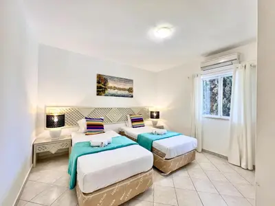 a bedroom with two beds and a window at Albufeira Balaia Golf Vilage 7 With Pool by Homing in Albufeira