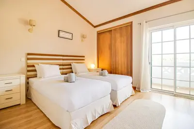 two white beds in a room with a window at Nature Escape 2BR Villa Pool Wi-Fi AC in Olhos de Água