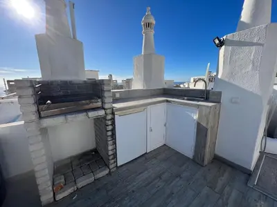 a kitchen with a sink and a lighthouse on a roof at Casa rooftop jacuzzi and magnificent sea view in Albufeira