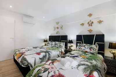 two beds in a room with white walls at Jungle Flat with Pool T2 Montechoro in Albufeira
