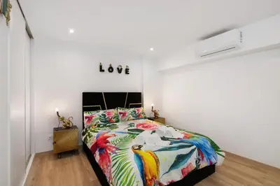 a bedroom with a bed with a love sign on the wall at Jungle Flat with Pool T2 Montechoro in Albufeira