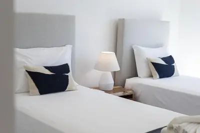 a bedroom with two beds with blue and white pillows at Terracos de Quarteira II White by Real Properties in Cavacos