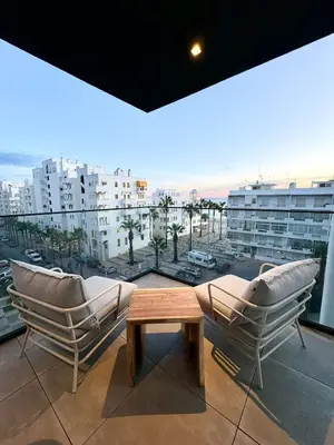 a balcony with two chairs and a coffee table on a building at Terracos de Quarteira II White by Real Properties in Cavacos
