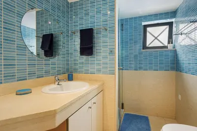 a bathroom with a sink and a mirror and a shower at Casa Peva in Albufeira