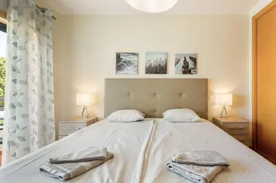 a bedroom with a large bed with two towels on it at Casa Peva in Albufeira